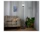Moderne staande lamp met glazen kap, naast een bank.
