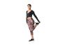 Femme en haut cache-cœur noir et leggings à motifs étirant sa jambe.