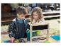 Twee kinderen spelen met een zandbak, schepjes en emmers.