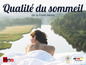 Une femme allongée dans un lit avec un système de sommeil Hna, sur fond de lac et de forêt.