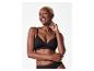 Femme souriante aux cheveux blonds courts, portant un soutien-gorge et une culotte noirs.