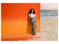 Vrouw in ESMARA® wide-leg broek met bloemenpatroon op het strand.