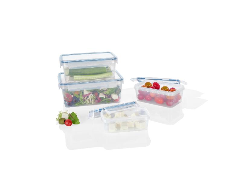 Drie doorzichtige opbergdozen met salade, feta en cherrytomaten.