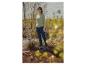 Vrouw in een lichtgroene geribbelde trui, donkerblauwe jeans en blauwe regenlaarzen buiten.