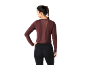 Femme en haut de sport bordeaux à manches longues et legging noir, vue arrière.