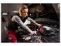 Femme travaillant sur un moteur de voiture, avec un chargeur de batterie Ultimate au premier plan.