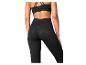 Femme de dos en legging noir imprimé léopard et brassière de sport