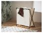 Een opvouwbare wasmand met drie compartimenten, van beige stof en een zwart frame, staat op een houten vloer.