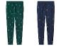Twee joggingbroeken, één groen met kerstbomen en één blauw met kerstmotieven.