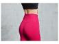 Une femme porte un legging rose taille haute.