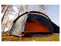 Een zwarte en oranje tent in een bos met openstaande ingang.