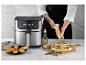 MasterPRO airfryer met gekookt eten en een persoon die kruiden toevoegt.