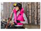Lachende vrouw in roze vest en Crivit ski-uitrusting.