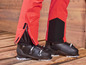 Rode ski broek met zwarte skischoenen.