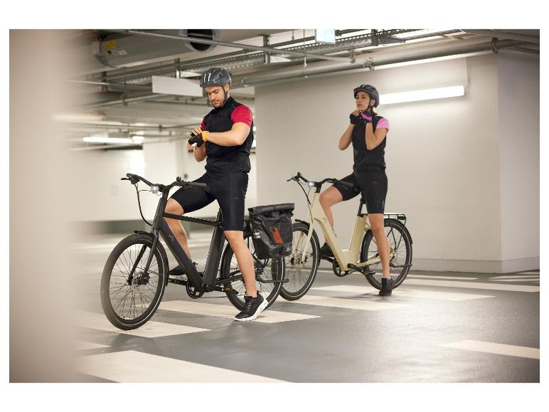 Twee elektrische fietsen en fietsers in een parkeergarage.