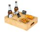 Plateau de service en bambou avec bouteilles de bière, snacks, ouvre-bouteille, télécommande et téléphone.