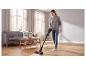 Femme passant l'aspirateur sans fil SILVERCREST® sur un parquet.