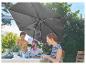 Tuinparasol en vrienden die buiten eten.