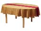 Ovale tafel met een goudkleurig gedessineerd tafelkleed en een rode tafelloper
