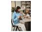 Een vrouw in een blauwe blouse leest een krant terwijl ze koffie drinkt in een café.