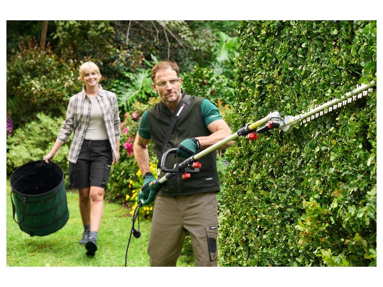 Homme taille une haie avec un taille-haie Parkside, femme porte un sac de jardin.