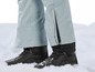 Zwarte winterschoenen in de sneeuw met lichtblauwe ski-broek