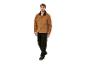 Een man draagt een camelkleurige Carhartt werkkledingjas en een zwarte broek.