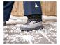 Grijze winterlaarzen met blauwe broek op de sneeuw.