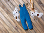 Blauwe ski-overall op een houten vloer met sneeuw.