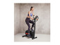 Een vrouw fietst op een zwarte hometrainer.
