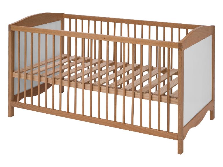 Un lit bébé en bois avec des barreaux.