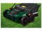Une tondeuse à gazon verte Parkside avec un bac de ramassage.