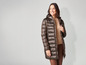 Une femme porte un manteau d'hiver marron.