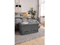 Banc de rangement gris avec tiroirs dans une chambre avec un lit à carreaux.
