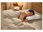 Un homme dort sur un oreiller en forme de U.