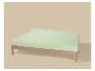 Houten bed met lichtgroen matras op beige achtergrond.