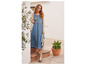 Een vrouw draagt een blauwe denimjurk en Birkenstock sandalen.