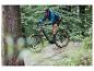 Un homme fait du vélo sur un VTT électrique gris dans la forêt.