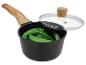 Zwarte pan met houten handvat, glazen deksel en groene erwten