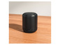 Een zwarte draagbare Bluetooth-luidspreker op een houten tafel.