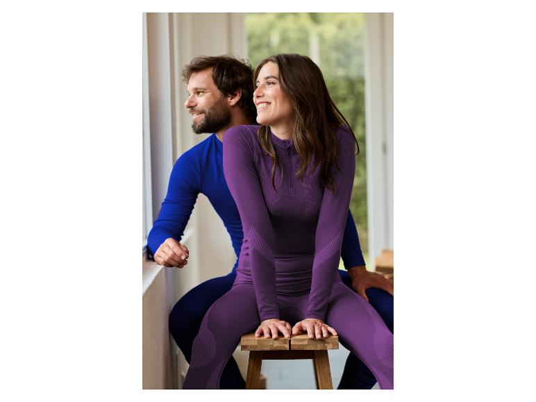 Couple en tenue de sport, femme assise sur un tabouret, homme derrière elle.