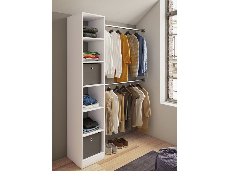 Une armoire blanche avec des étagères et une barre de penderie, pleine de vêtements.