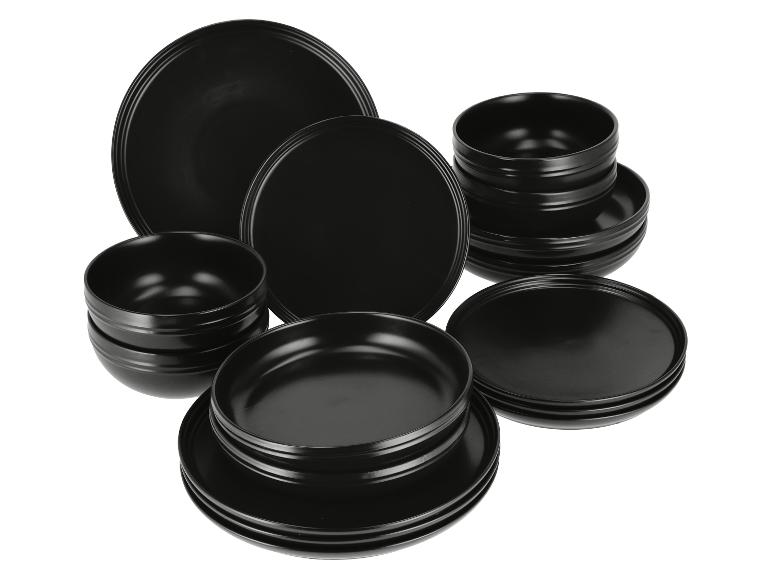 Service de table noir avec assiettes et bols de différentes tailles.