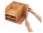 Handen monteren een houten bureau-organizer met meerdere vakken en planken.