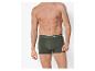 Homme en caleçon boxer vert foncé avec texte blanc sur la ceinture.