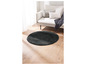 Een rond grijs vloerkleed op een houten vloer