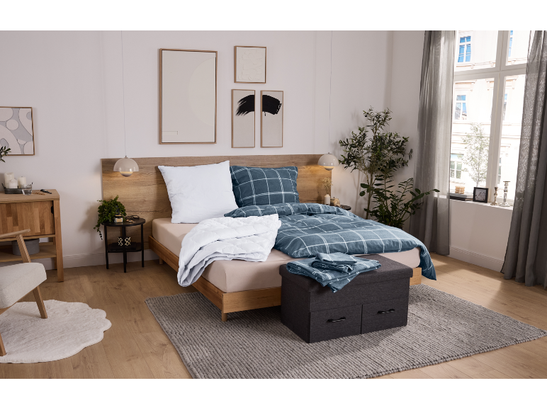 Chambre douillette avec lit en bois, parure de lit à carreaux bleus et tapis gris.