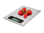 Digitale keukenweegschaal met aardbeien, toont '74 g'.