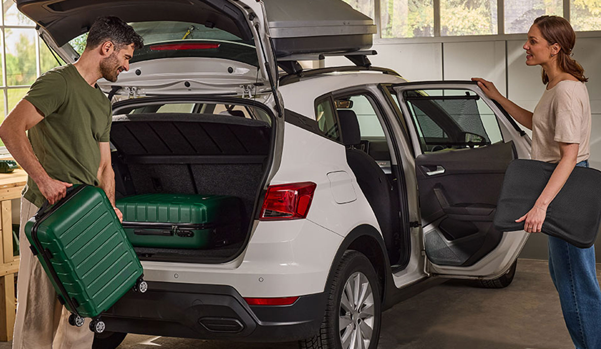 Couple chargeant bagages et accessoires de voiture dans un SUV blanc pour un voyage.