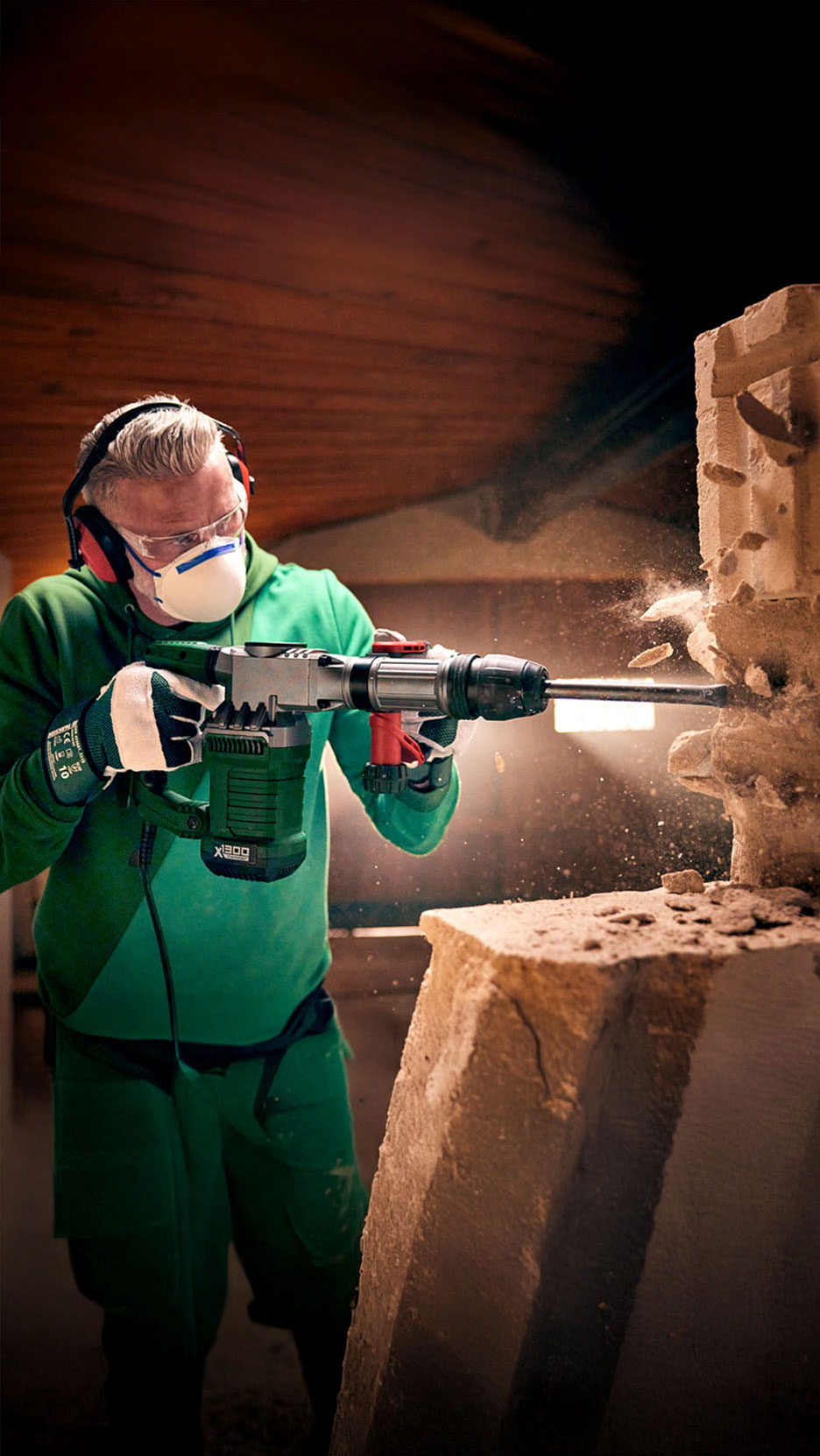 Een arbeider breekt een muur af met een Einhell X-Hammer 1800.